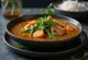 Sinigang s korením tandoori, ozdobený čerstvým koriandrom