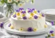 Jarná kvetinová torta zdobená jedlými kvetmi