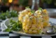 Esquites s koriandrom, podávané s kyslou smotanou a kolieskami limetky