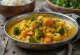 Miska Kootu curry so šošovicou, mrkvou, plantainmi a brokolicou v zlatej omáčke z kokosového mlieka.