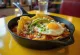 Čerstvé chilaquiles con aguacate, podávané s avokádom a volským okom